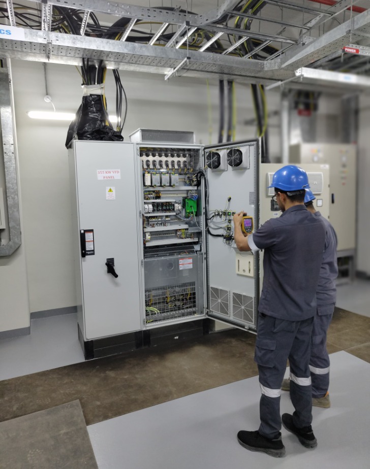 PAL Cooling LLC technicians inspecting a centralized district cooling control panel in Abu Dhabi